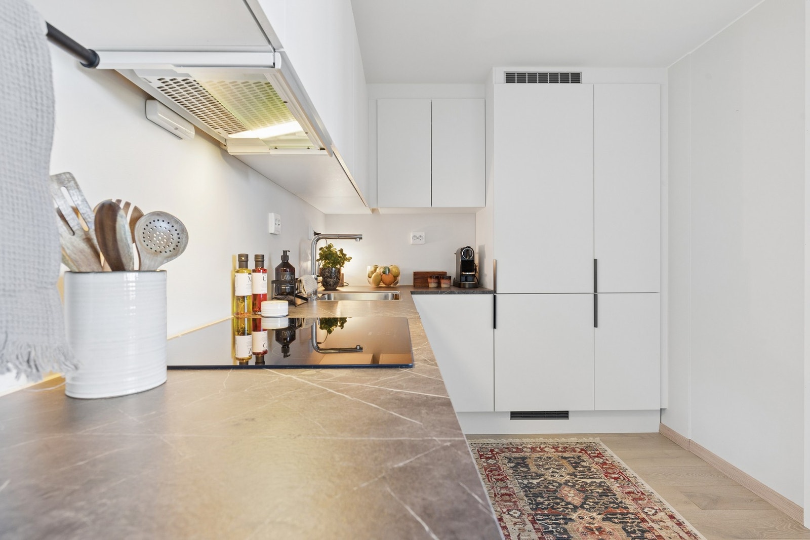 Kjøkkenet har rustfri stålkum, integrert koketopp, komfyr, oppvaskmaskin og kjøl/frys. Ventilator over koketopp. Galleribilde