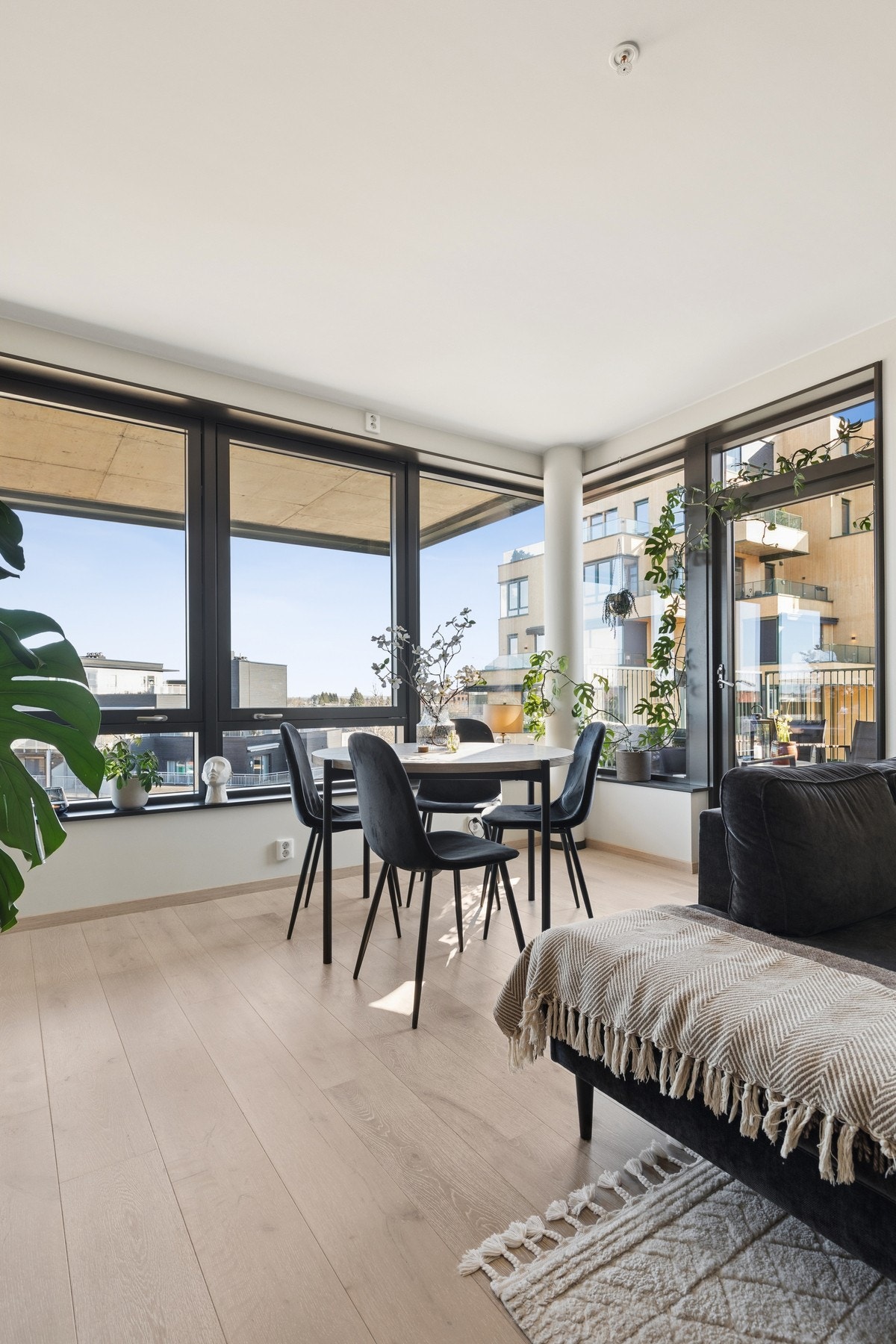 Lys og moderne stue med store vindusflater og utgang til balkong. Galleribilde