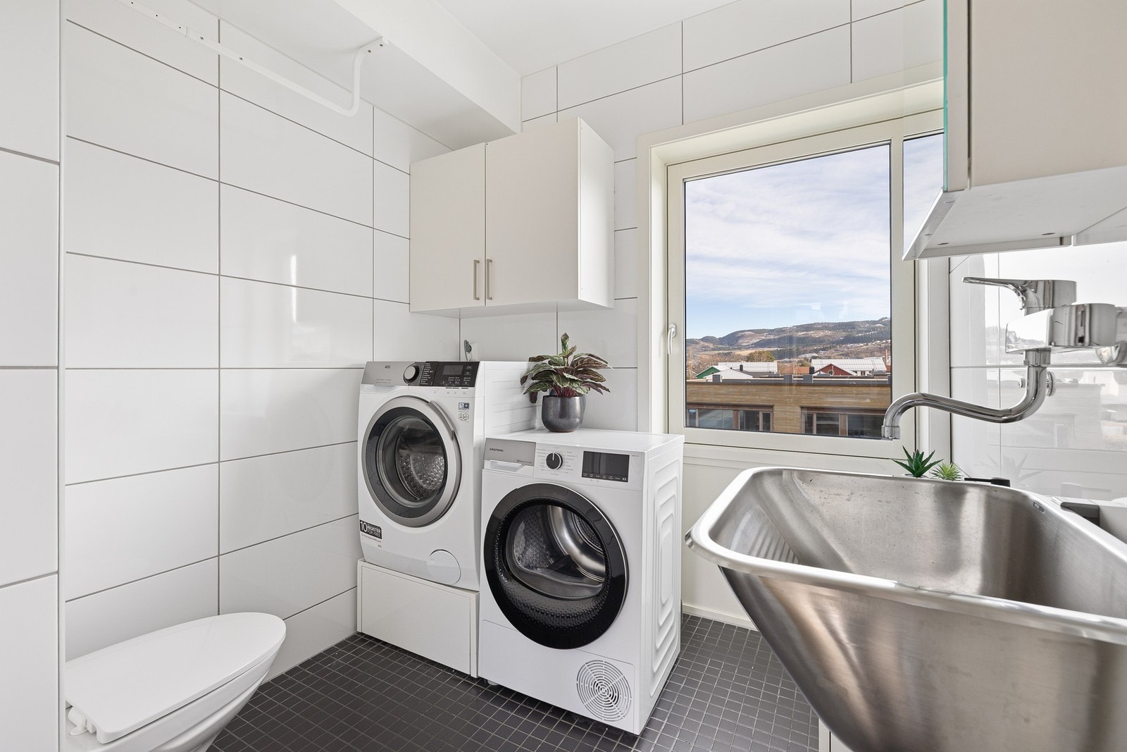 Boligens vaskerom er på ca. 4,5 kvm. Flere naboer har satt inn et dusjkabinett og benytter dette som et bad nr. 2. Galleribilde