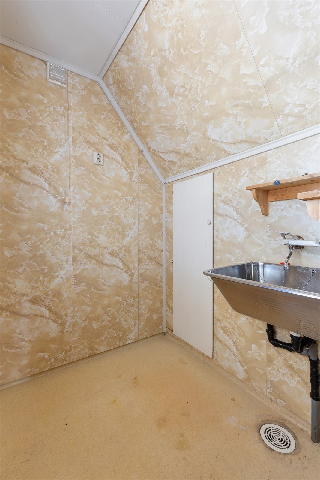 Enkelt vaskerom med våtromsplater på veggene og belegg på gulv. Innredet med utslagsvask. Galleribilde