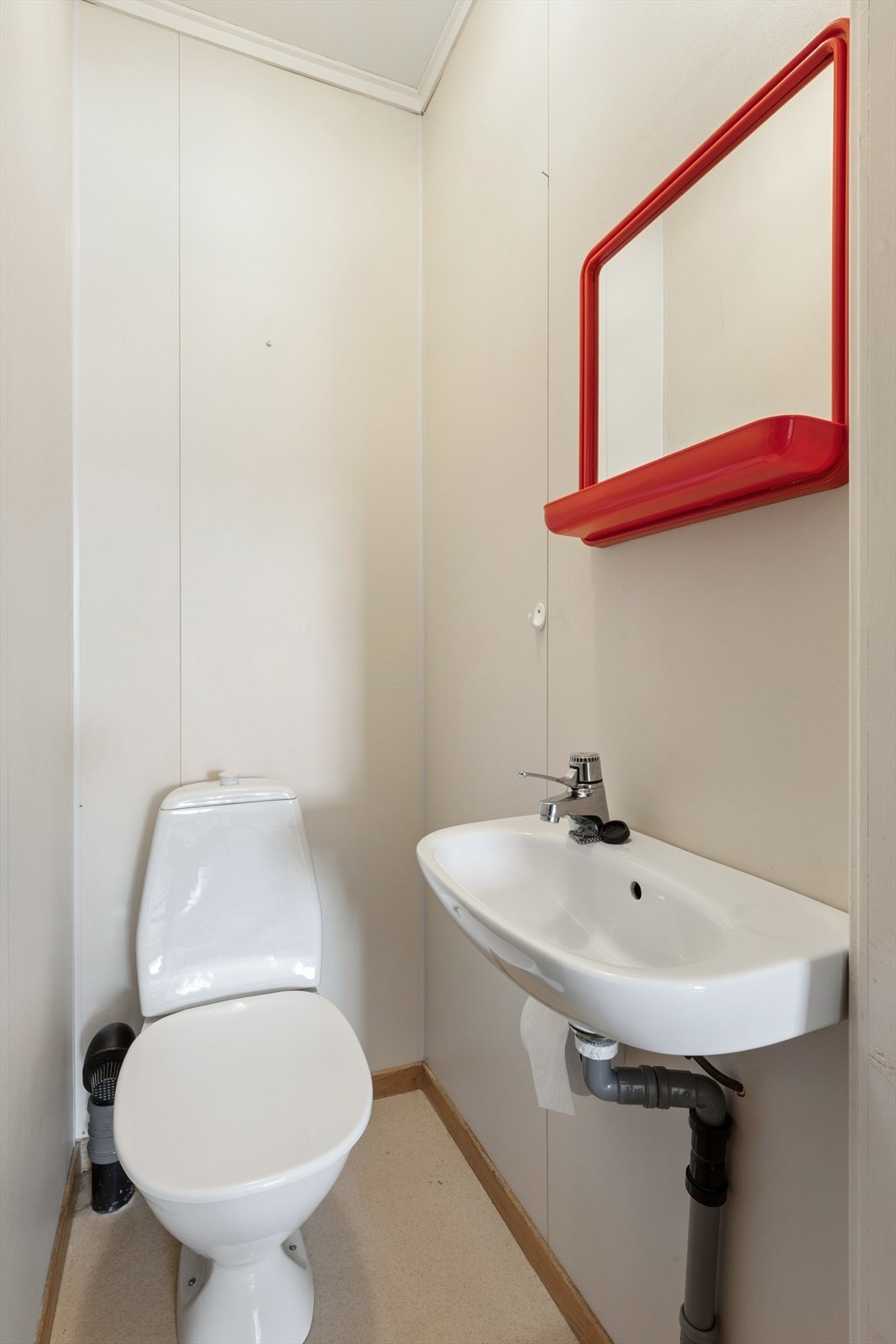 Enkelt toalettrom med servant og wc. Galleribilde