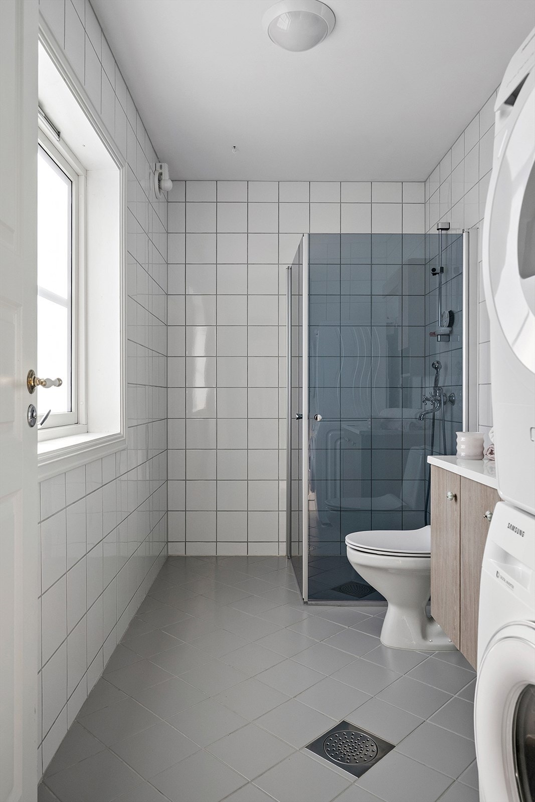 Romslig bad med dusjhjørne og vaskemaskin. Galleribilde