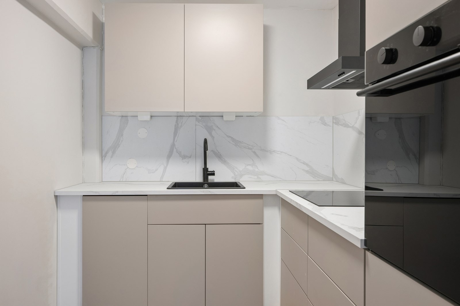 Innredningen har glatte, sandfargede fronter og benkeplate i lys laminat med steinimitasjon. Galleribilde