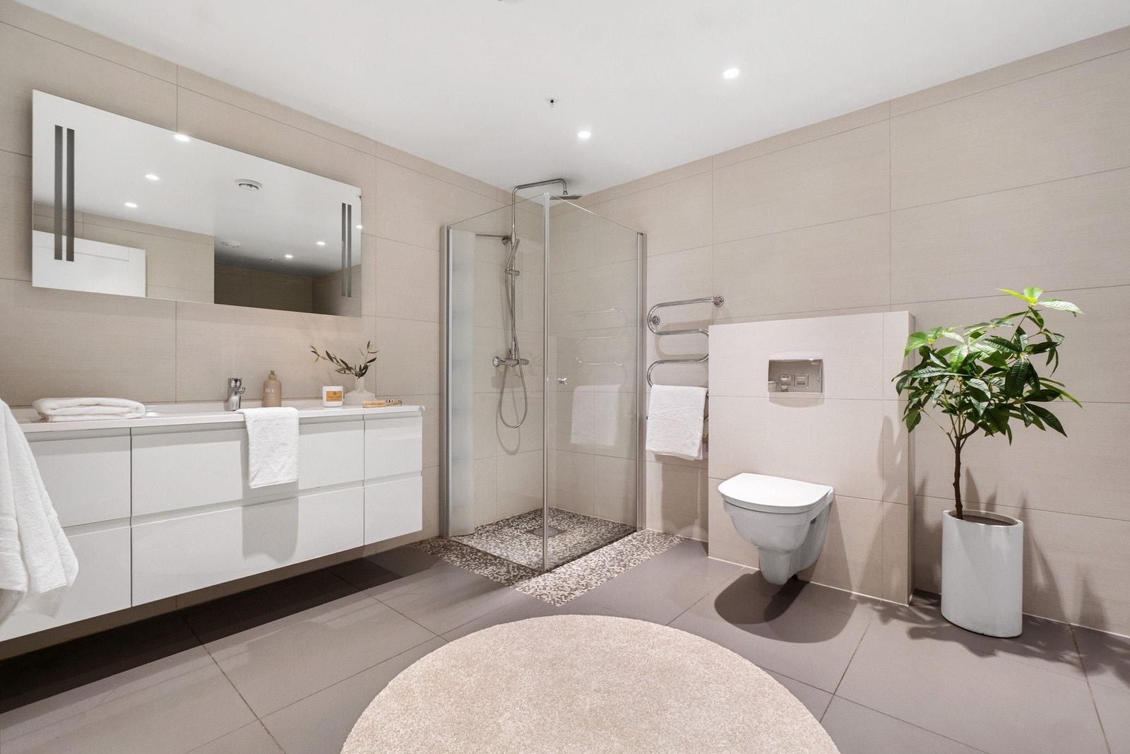 Innbydende bad/vaskerom som er flislagt med elektriske varmekabler i gulv. Galleribilde