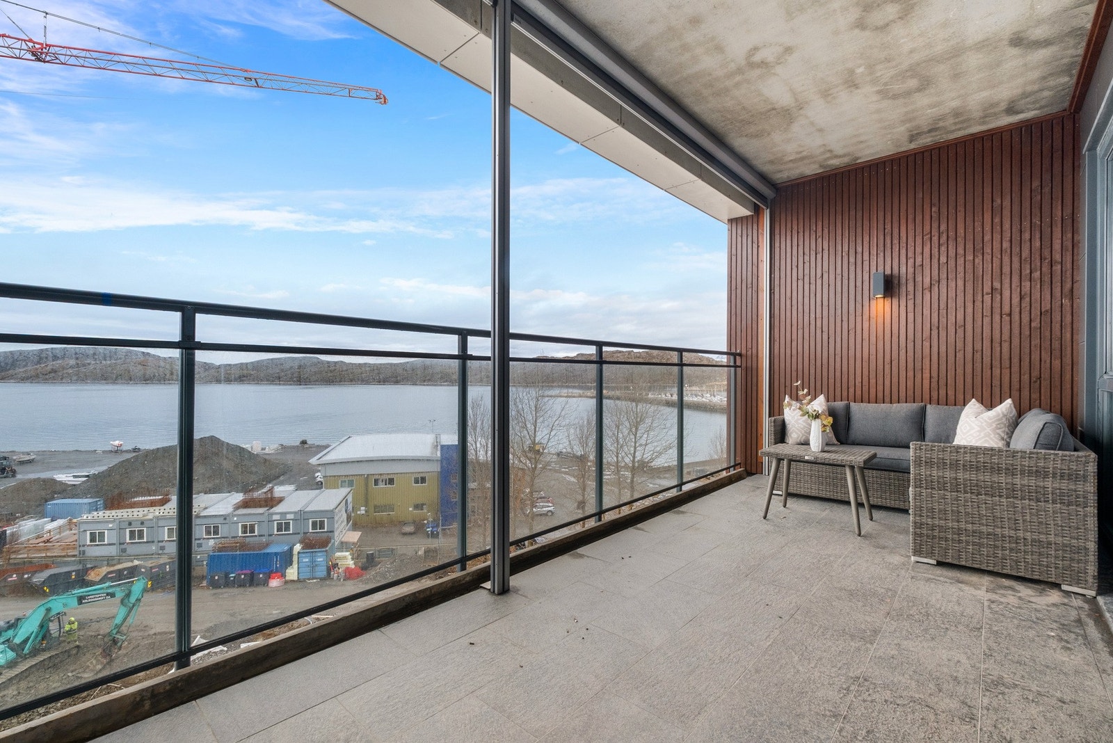 Utgang fra stua til en overbygd balkong med gode solforhold og nydelig utsikt over hav og fjell. Galleribilde