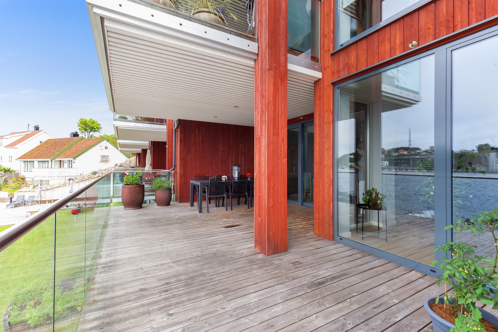 Delvis overbygget veranda med kebony terrassebord og glassrekkverk. Galleribilde