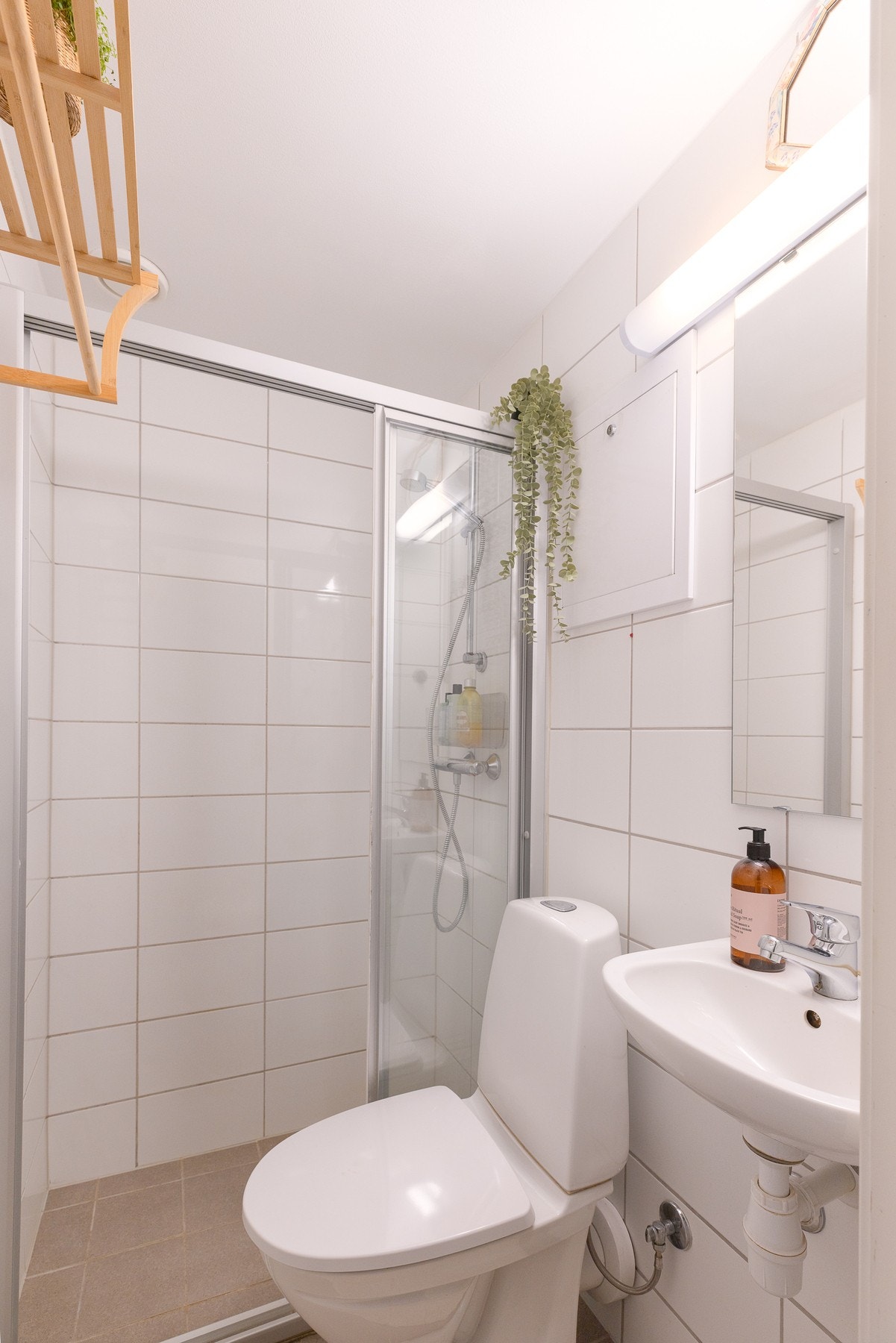 Baderommet er unnrdet med gulvstående toalett, servant og dusj med dusjdører. Galleribilde