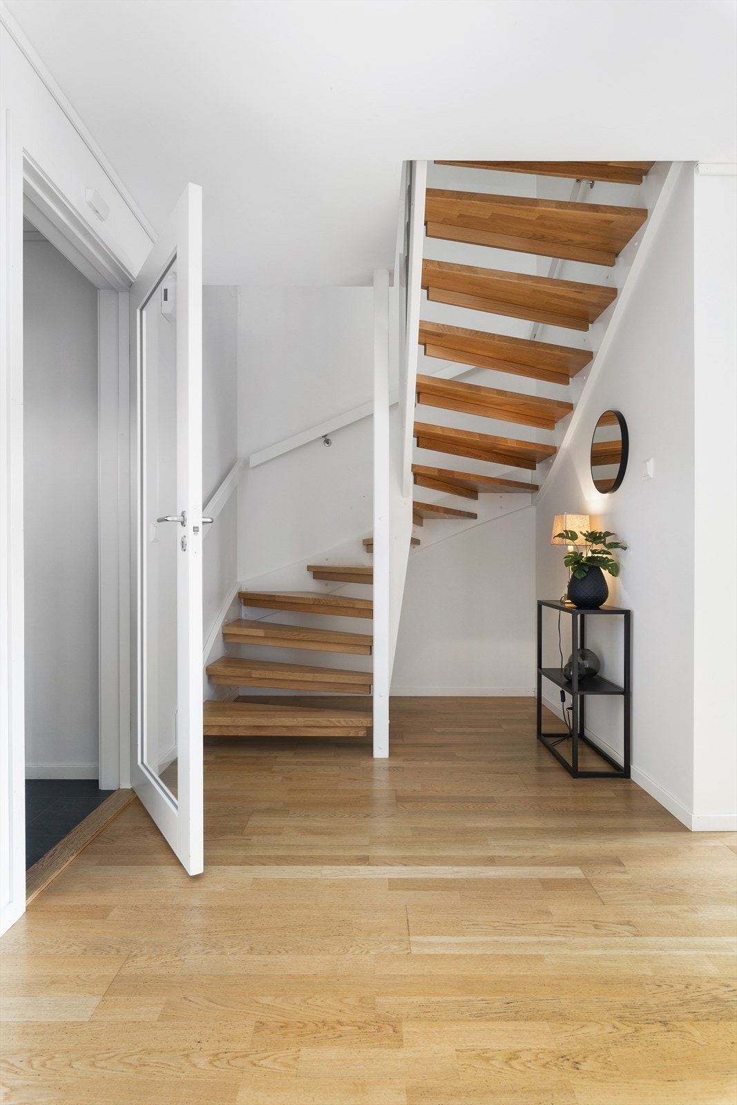 Svingtrappen er av tre og har trinn av lakkert eik. Galleribilde
