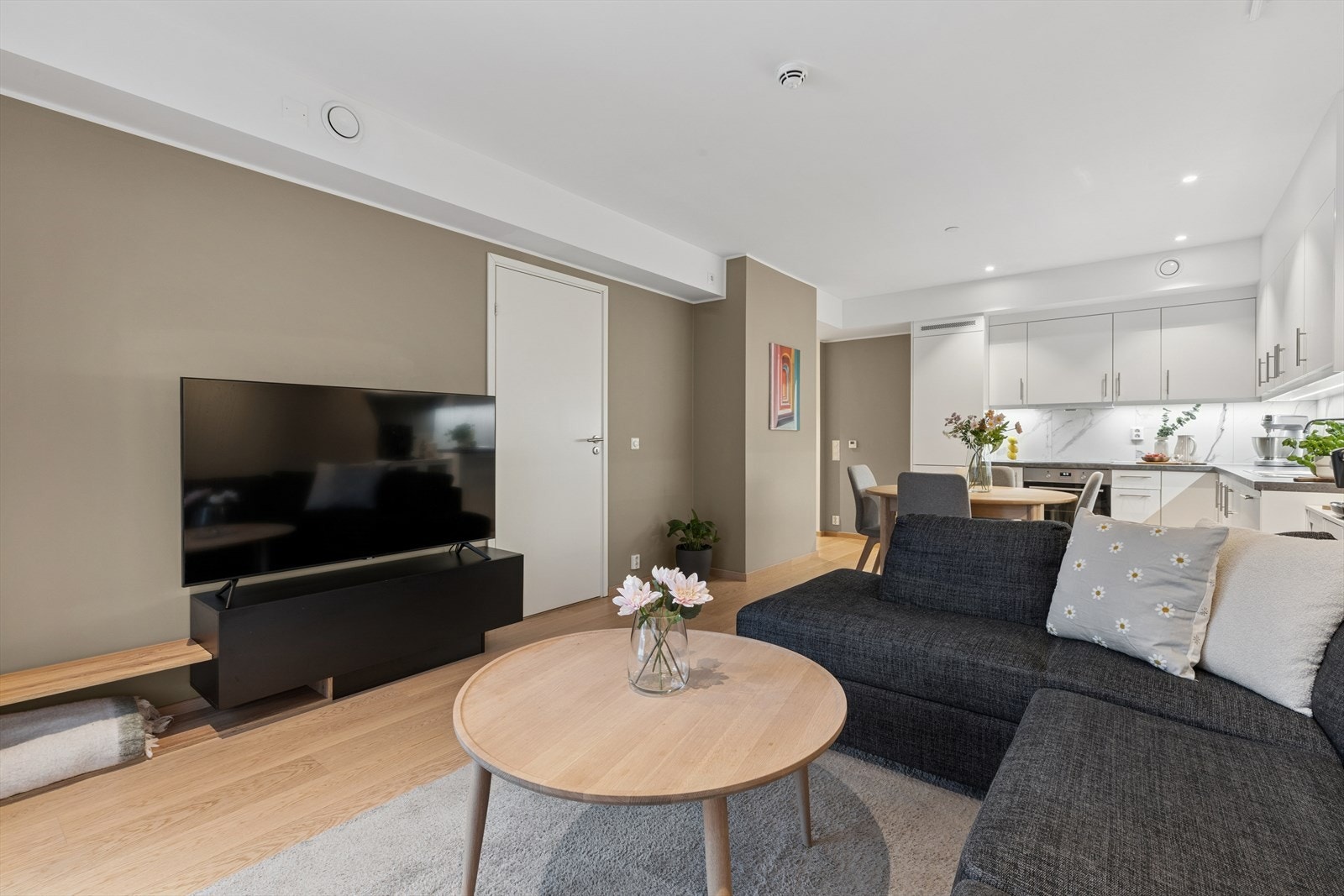 Det åpne kjøkkenet gir rom for et hyggelig spisebord i tilknytning til stuen, og gjør det lett å kombinere matlaging og samvær. En løsning som gir god flyt og utnytter boligens arealer optimalt. Galleribilde