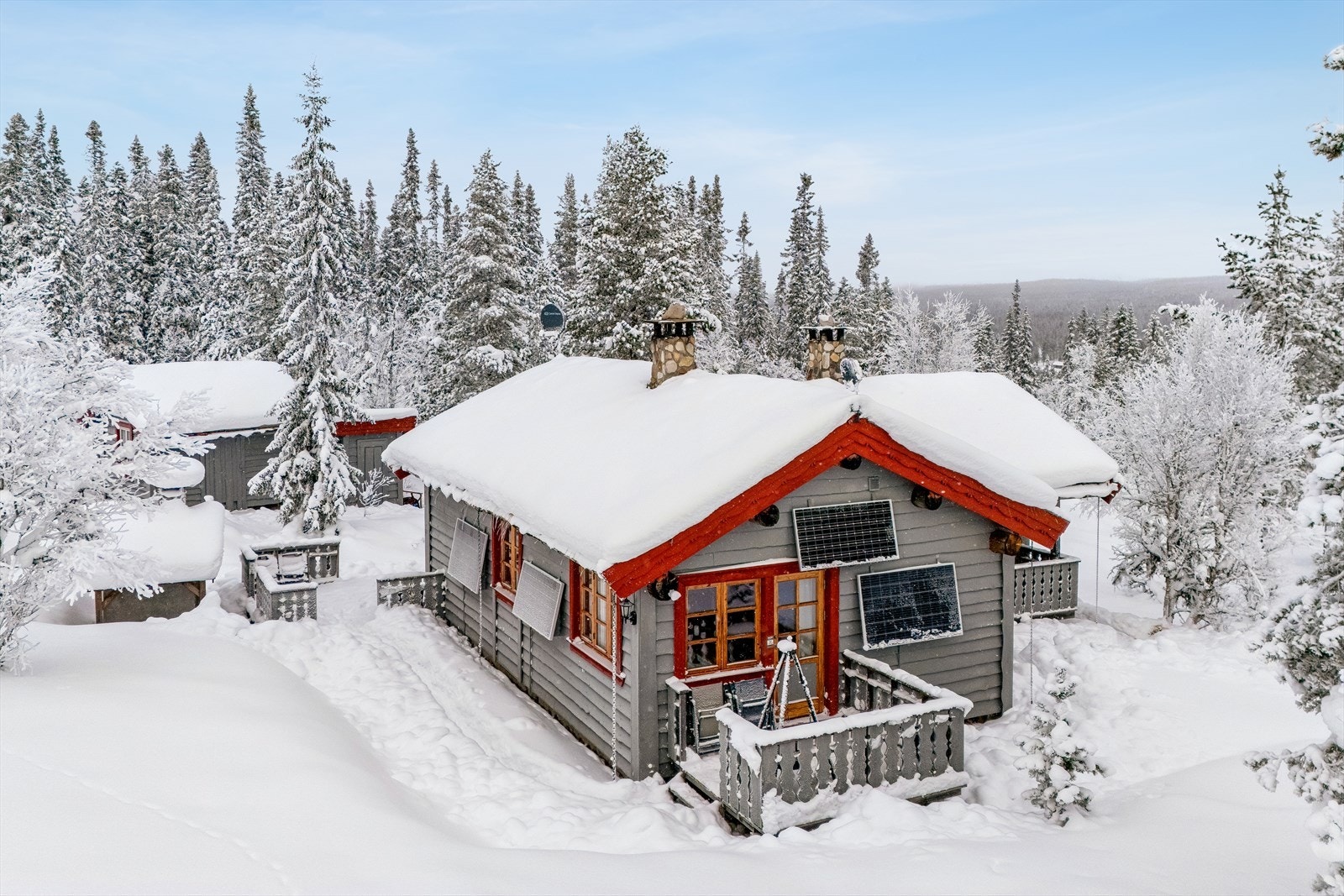 En klassisk hytte med torvtak, idyllisk plassert i et snødekt skogsterreng. Galleribilde