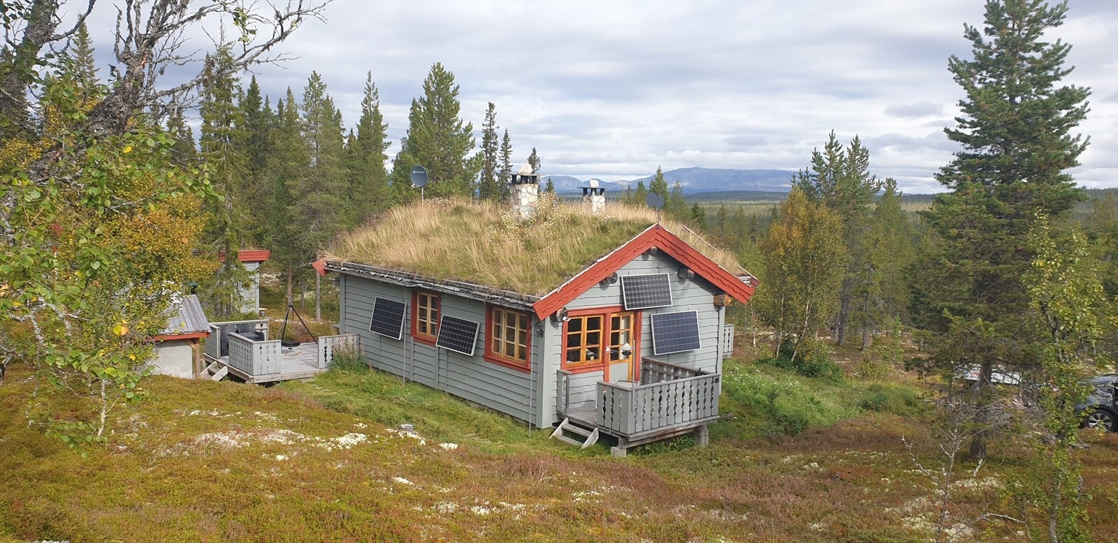Hytta glir fint inn i terrenget, her vist i sommerdrakt. Selgers foto. Galleribilde