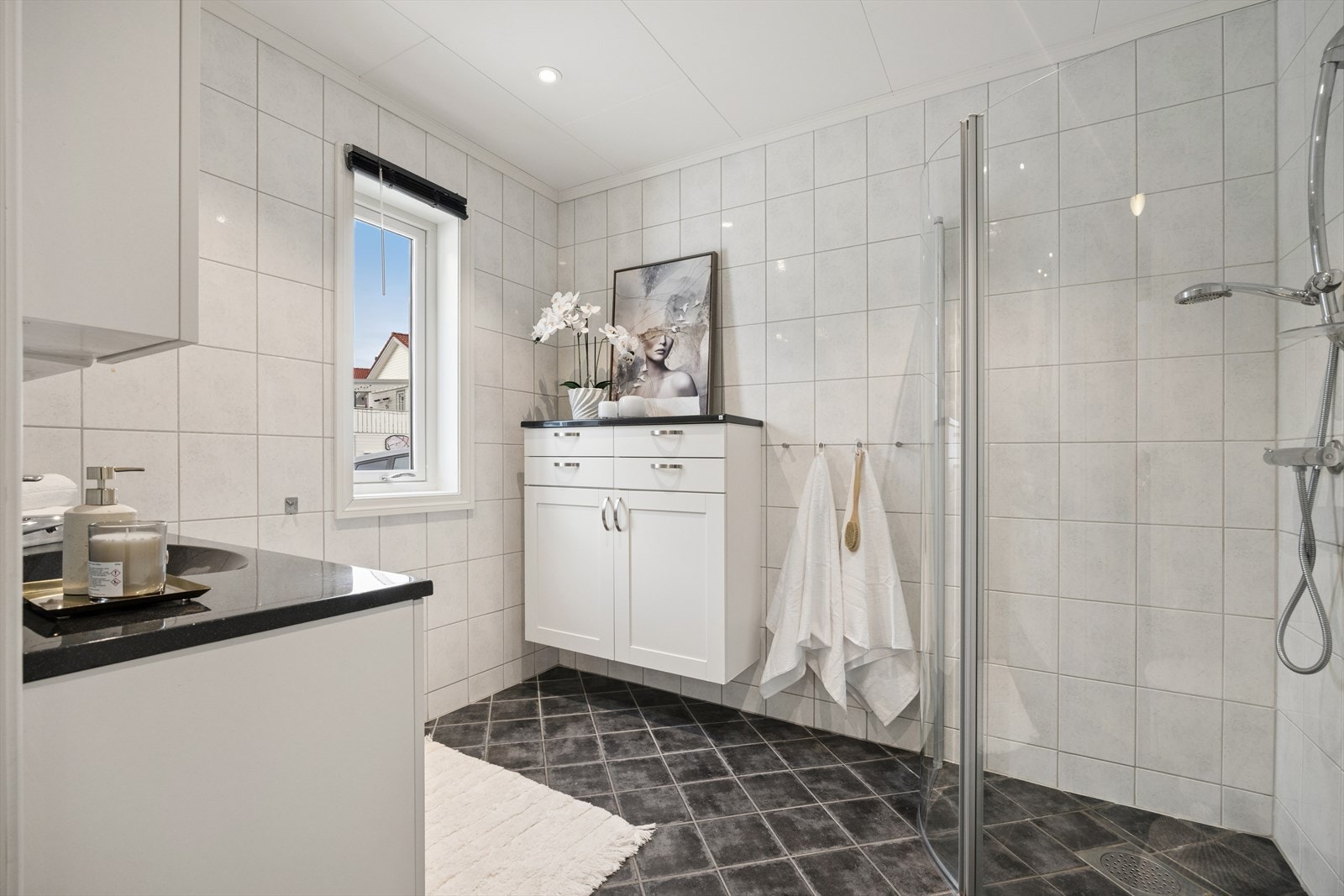 Dusjsonen har praktiske glassvegger og veggmontert dusjgarnityr. Galleribilde