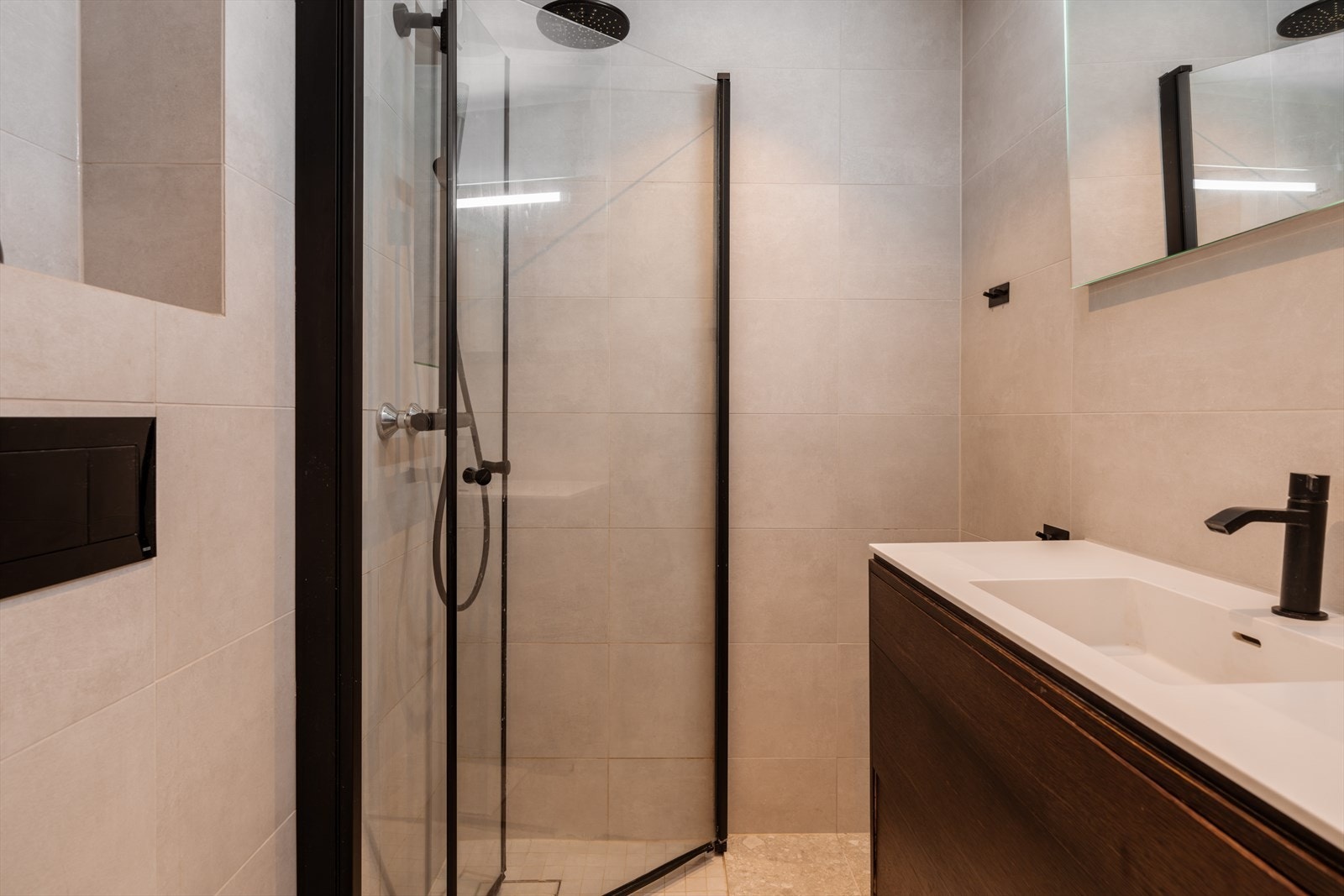 Innredning bestående av vegghengt toalett, servant med skuffer og dusjhjørne med glassdør Galleribilde