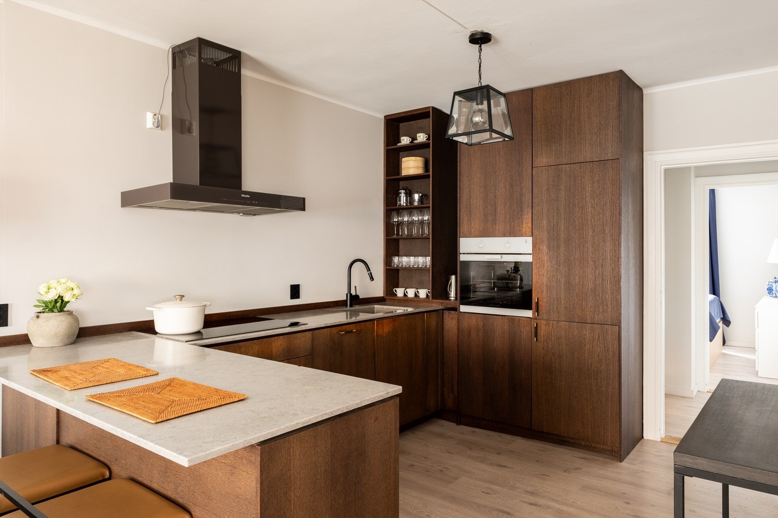 Lekkert og moderne kjøkken med slette fronter og benkeplate i steinkompositt Galleribilde