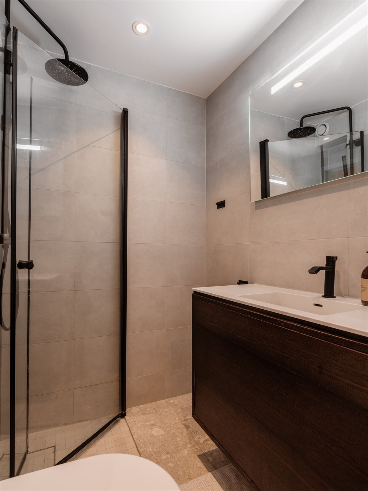 Lekkert baderom pusset opp i 2019 med dusjhjørne med dører i herdet glass. Vegghengt toalett. Galleribilde