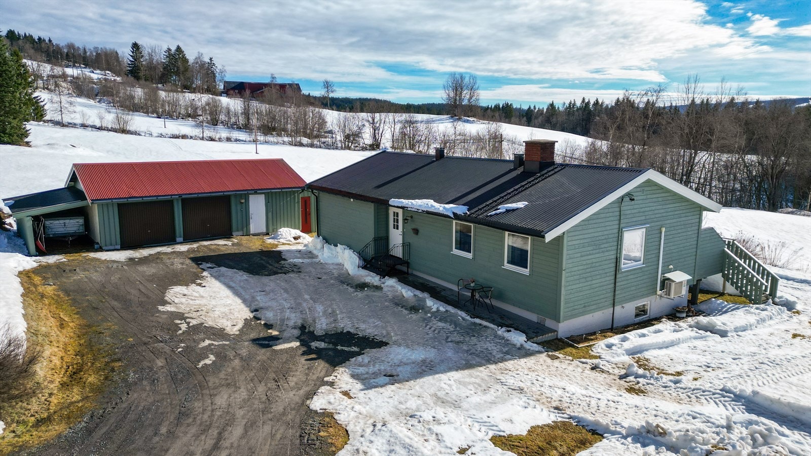 Eiendommen inkluderer en romslig, frittstående garasjebygning med verksted, bod, carport og innlagt elbillader. Galleribilde