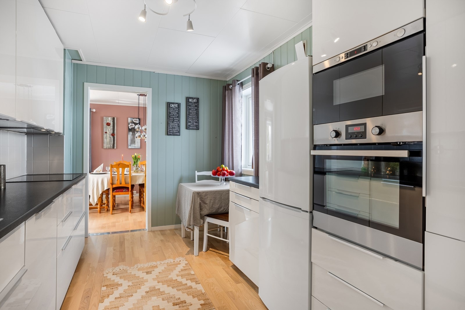 Kjøkkenet har en praktisk spiseplass og åpen siktlinje mot spisestuen. Galleribilde