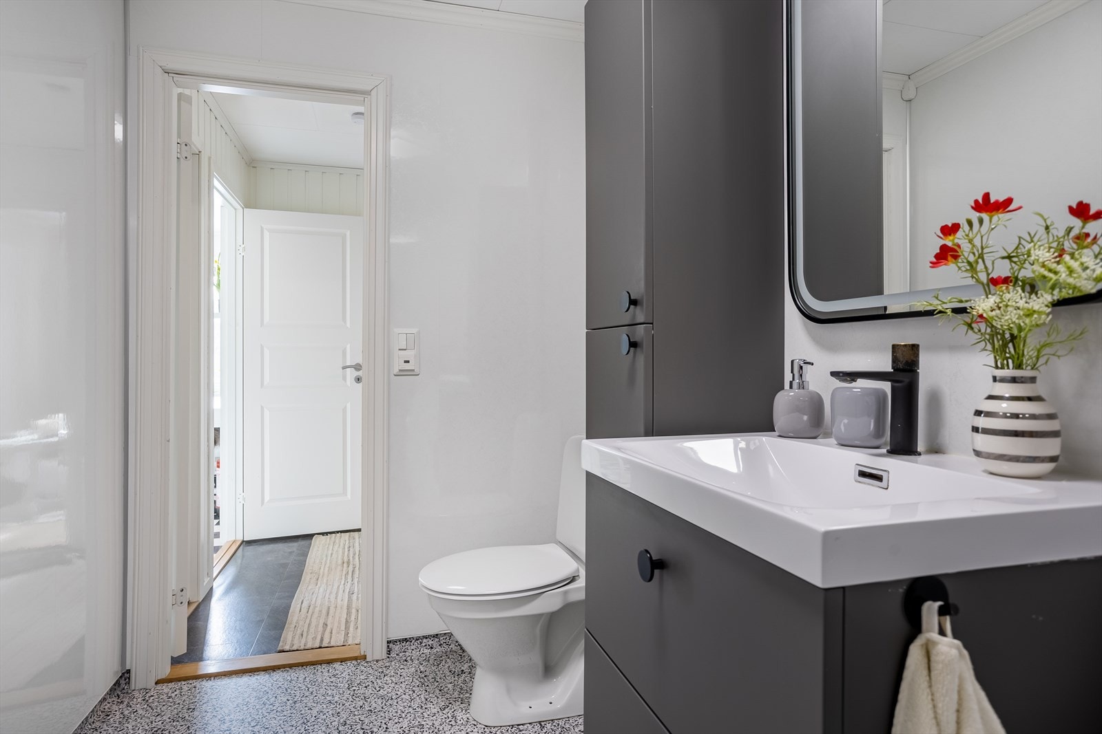 Badet er utstyrt med baderomsinnredning, gulvmontert toalett og opplegg for vaskemaskin. Galleribilde