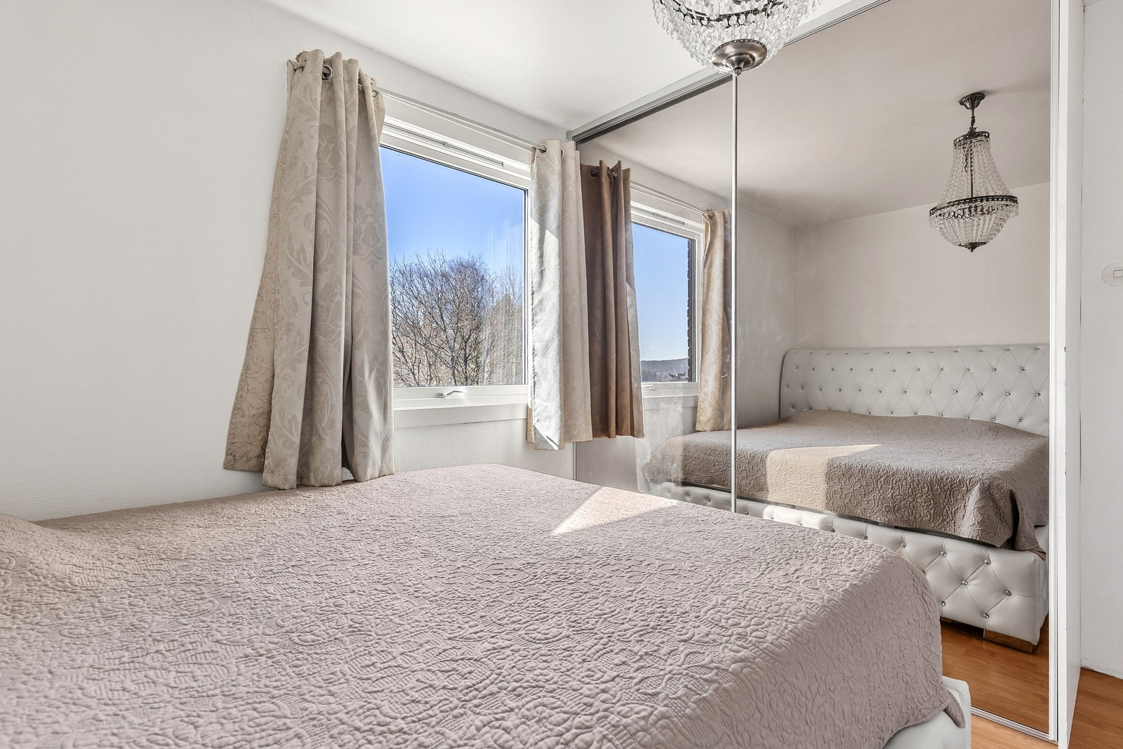 Det er rikelig med oppbevaringsplass i en stor skyvedørsgarderobe med speilfronter. Galleribilde