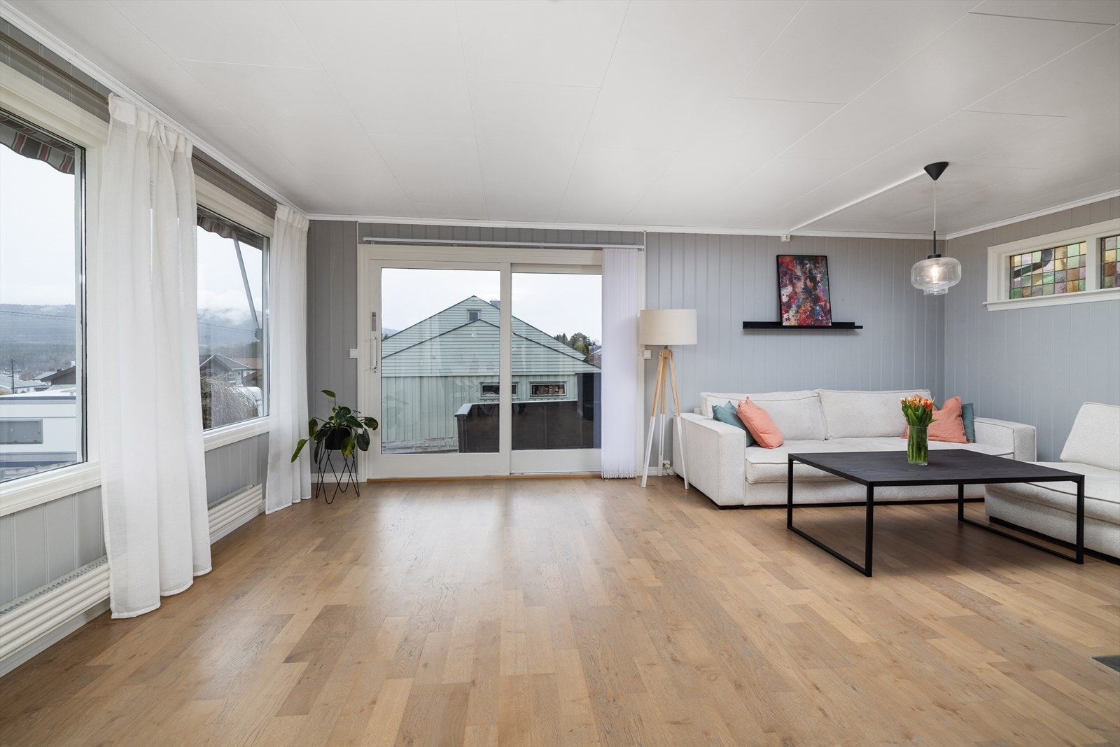 En bred heve-/skyvedør fra 2016 åpner opp mot den sørvendte uteplassen og slipper dagslyset inn. Galleribilde