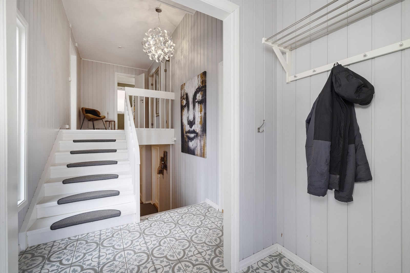 Vindfanget har flislagt gulv med varmekabler og leder inn til en lys og åpen gang. Galleribilde