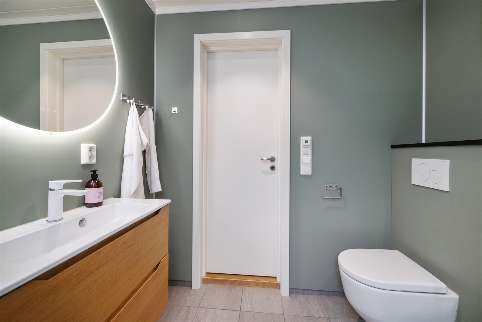 Badet i første etasje er utstyrt med vegghengt toalett og en moderne baderomsinnredning. Galleribilde