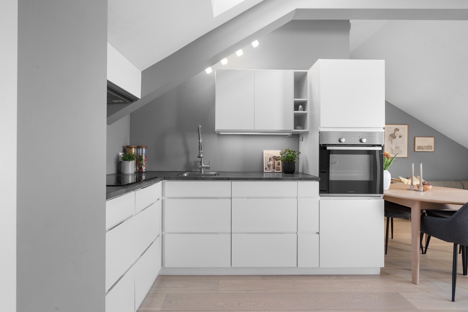 Innredningen har hvite glatte fronter og laminert benkeplate med nedfelt oppvaskkum. Galleribilde