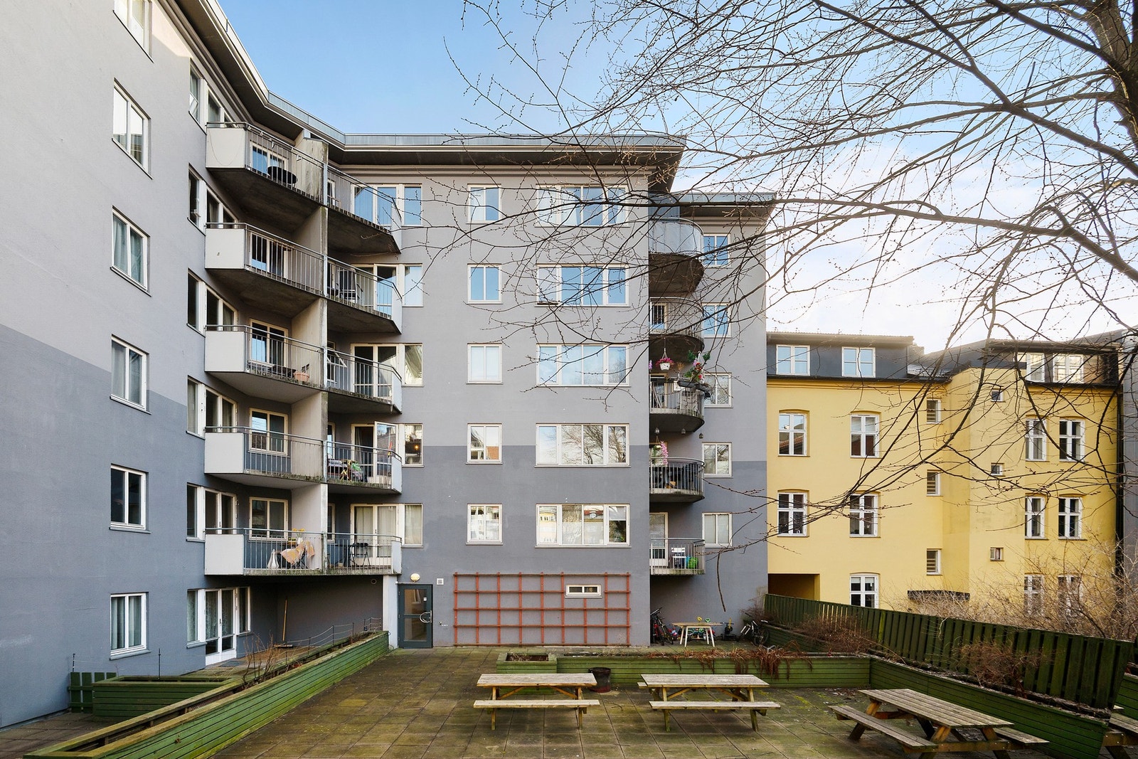 Bakgården har sittegrupper og beplantning Galleribilde