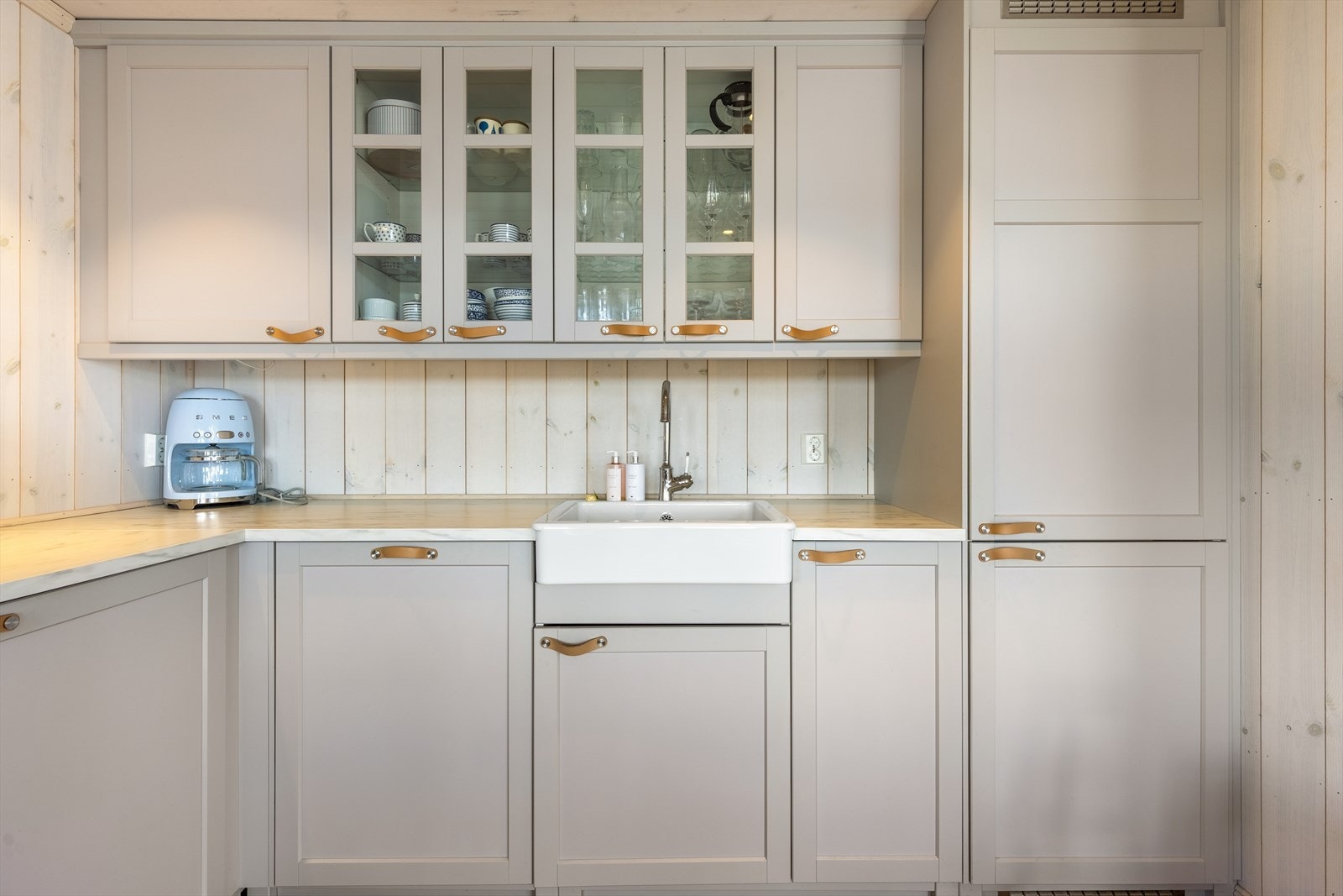 Fabrikkfremstilt innredning med underskaper og overskaper. Innredningen er utført med slette malte fronter og laminert benkplate Galleribilde