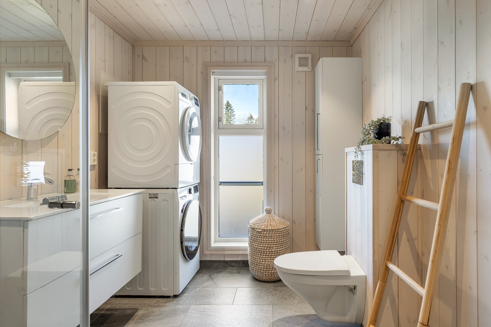 Kombinert bad/vaskerom i fritidsboligens hovedetasjen. Flislagt gulv. Bad/vaskerommet er utstyr med elektrisk gulvvarme. Baderommet er utstyrt med standard toalett, servantinnredning, dusjkabinett og opplegg for vaskemaskin Galleribilde