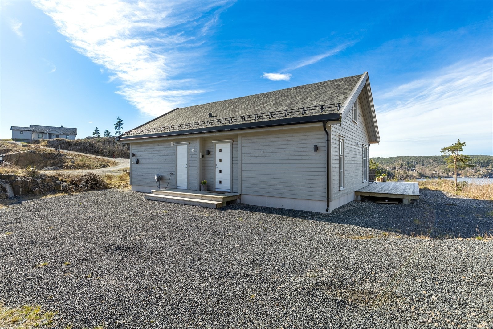 Gruslagt parkeringsplass med plass til flere biler. Bod med utvendig adkomst Galleribilde