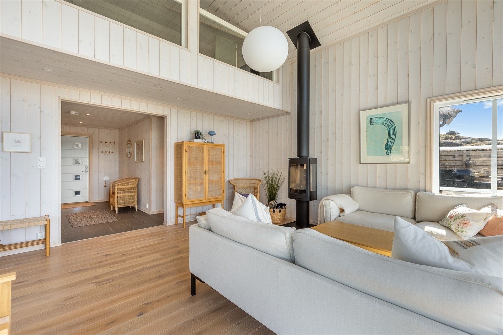 Fritidsboligen fremstår som moderne og stilren, har store vindusflater som slipper både naturen og dagslys inn. Det er åpen himling i stuen opp mot hemsen, noe som gir en luftig og god romfølelse Galleribilde