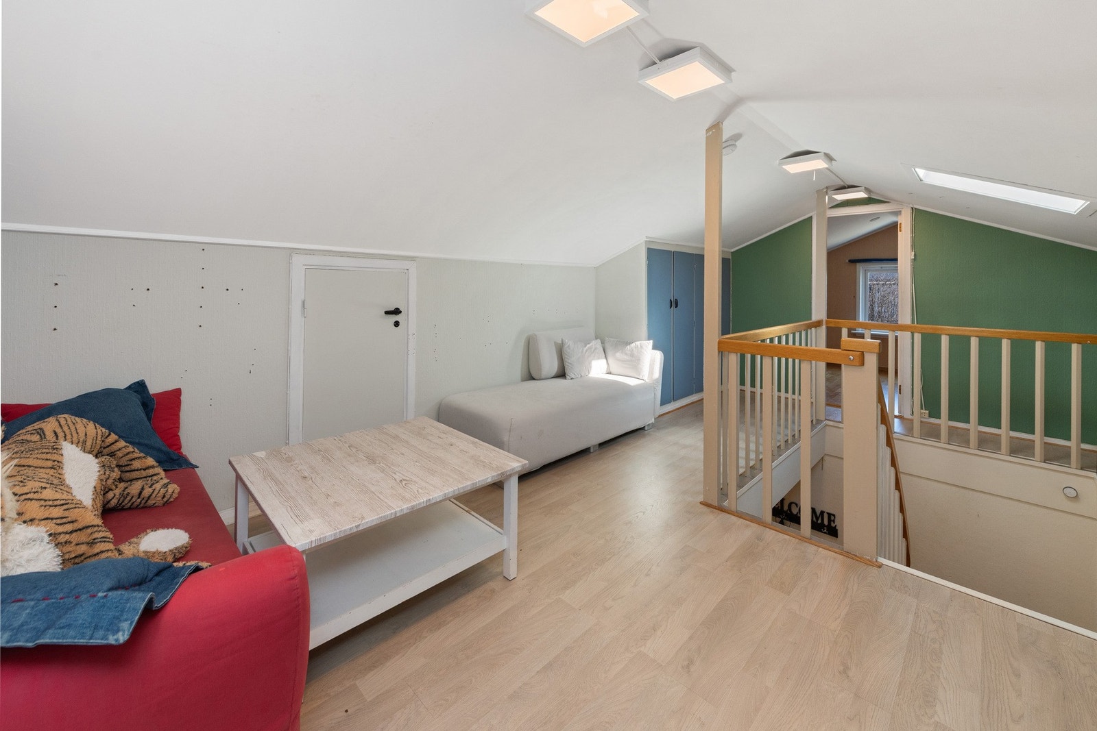 Lys og luftig loftstue med skråtak. Ett vindu i tak. Galleribilde
