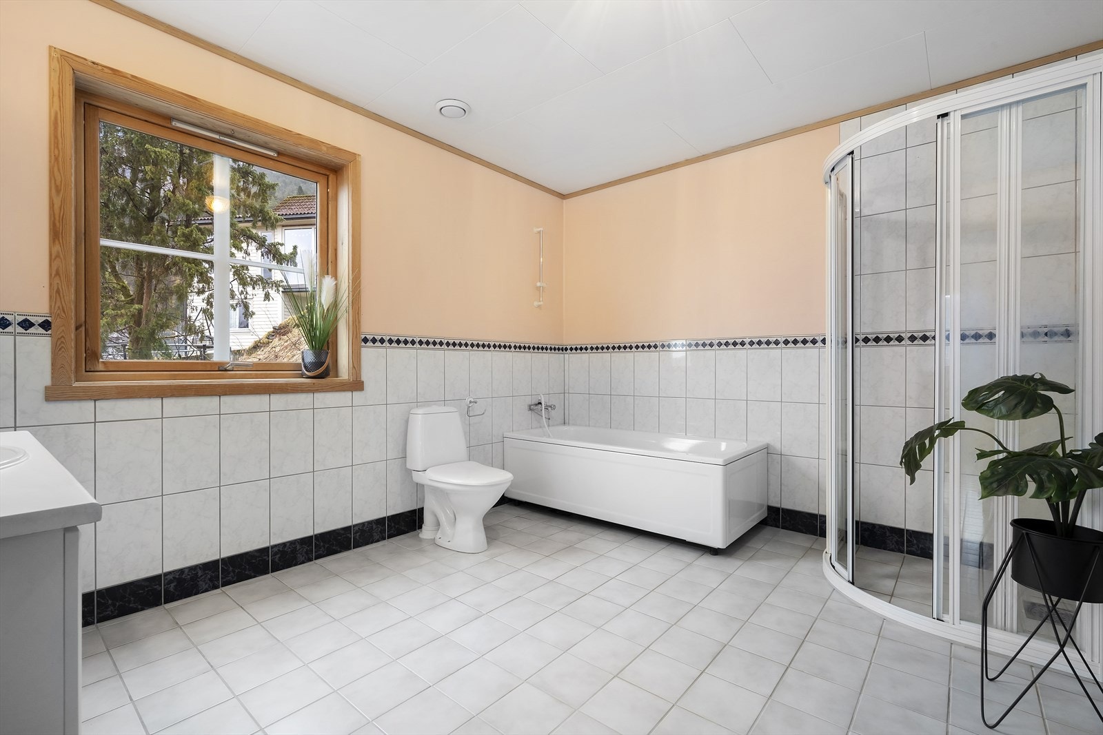 Badet har flislagt golv med varmekablar og delvis flislagde veggar Galleribilde