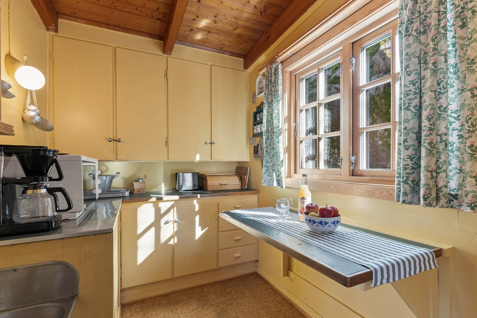 Kjøkkeninnredningen er av eldre dato og består av lyse, glatte fronter og laminert benkeplate med nedfelt kjøkkenkum. Galleribilde