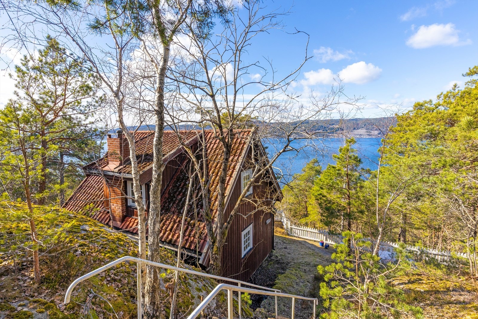 Tomten består av en vakker naturtomt med innslag av fjell, trær, plen og naturlig vegetasjon, noe som gir eiendommen et usjenert og fredelig preg. Galleribilde