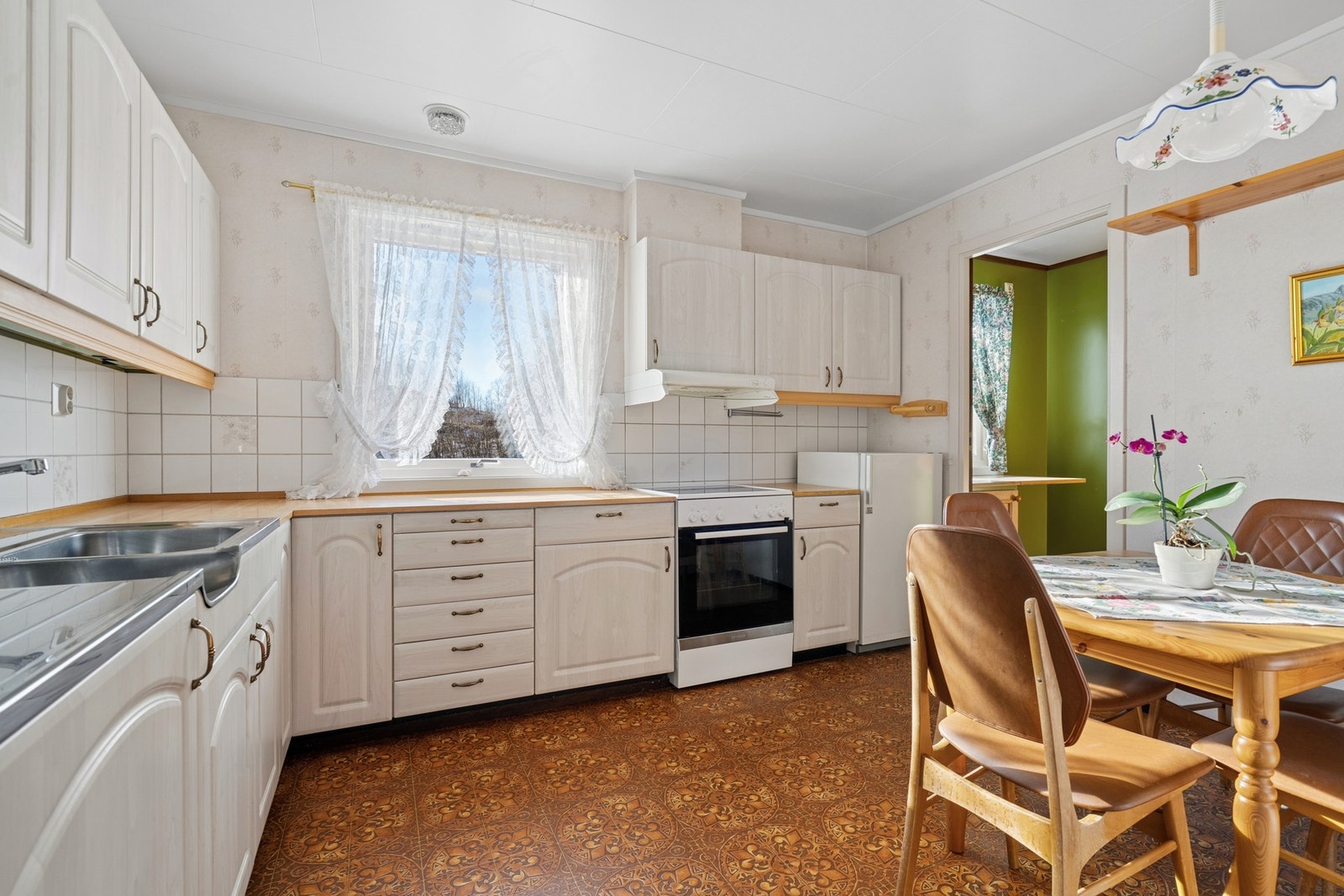 Kjøkkenet er utbygget med god skap- og benkeplass med innredning i profilerte fronter. Galleribilde