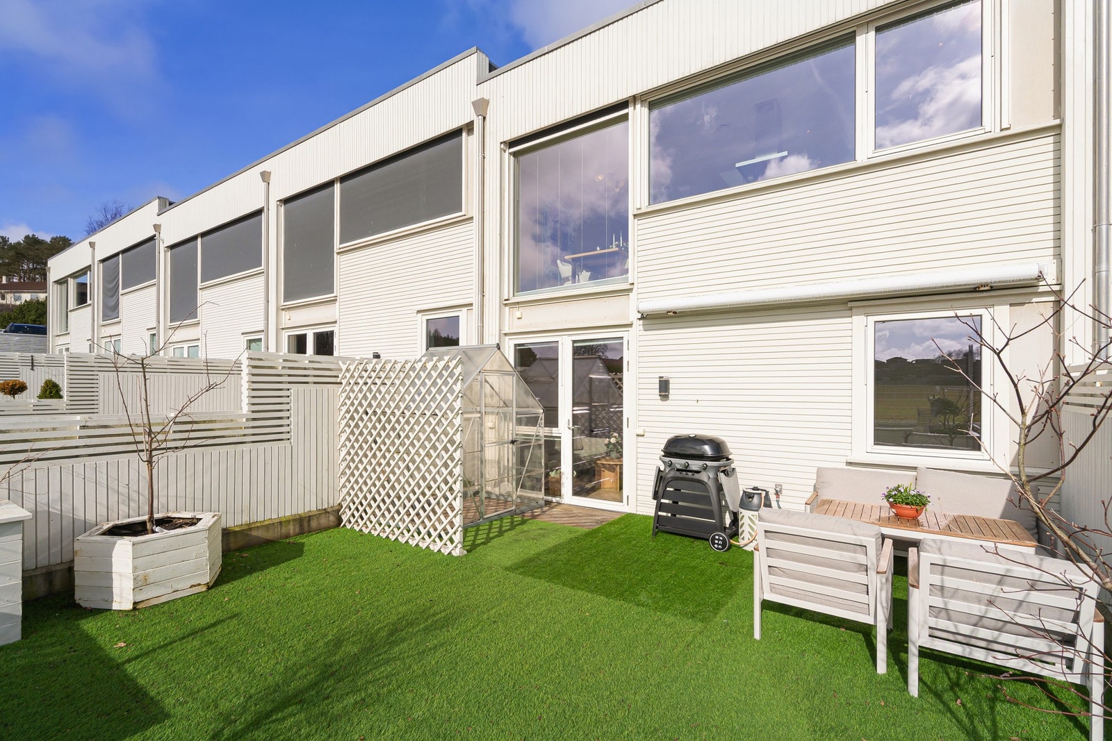 Skjermet terrasse med drivhus, perfekt for hobbydyrking og utekos Galleribilde