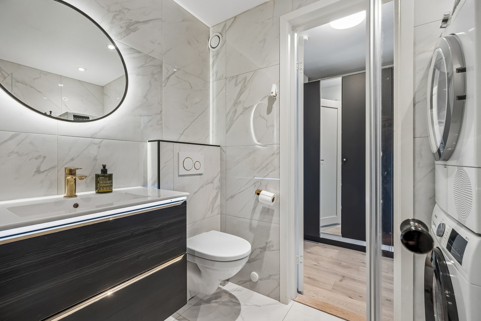 Rommet er godt utnyttet og innredet med servant i innredning, speil, toalett og dusjløsning, samt opplegg for vaskemaskin som bidrar til en funksjonell og plassbesparende løsning i hverdagen. Lyse materialvalg og god belysning gir en behagelig romfølelse. Galleribilde