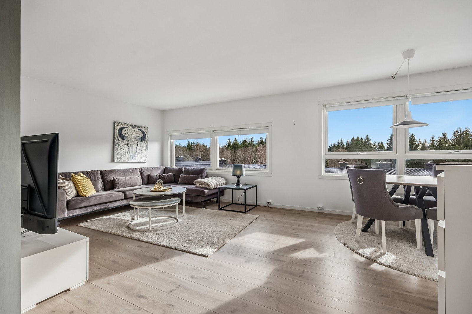 Rommet har en åpen og fleksibel utforming som gir gode møbleringsmuligheter, enten du ønsker en stor sofagruppe, TV-løsning eller et mer sosialt oppsett med flere sitteplasser. Galleribilde