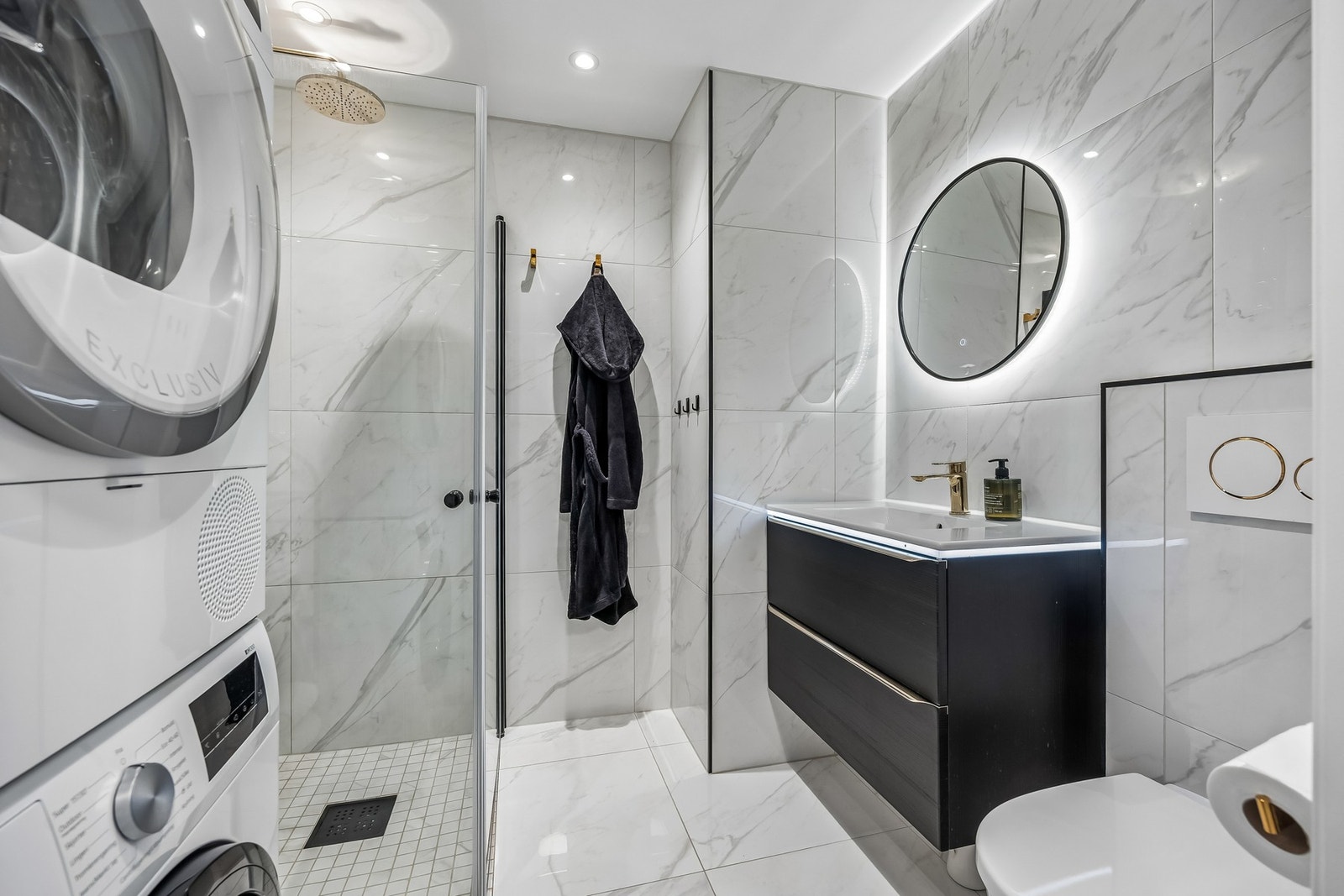 Badet fremstår som moderne og stilrent med flislagte overflater på både gulv og vegger, noe som gir et tidløst uttrykk og er praktisk med tanke på vedlikehold. Galleribilde