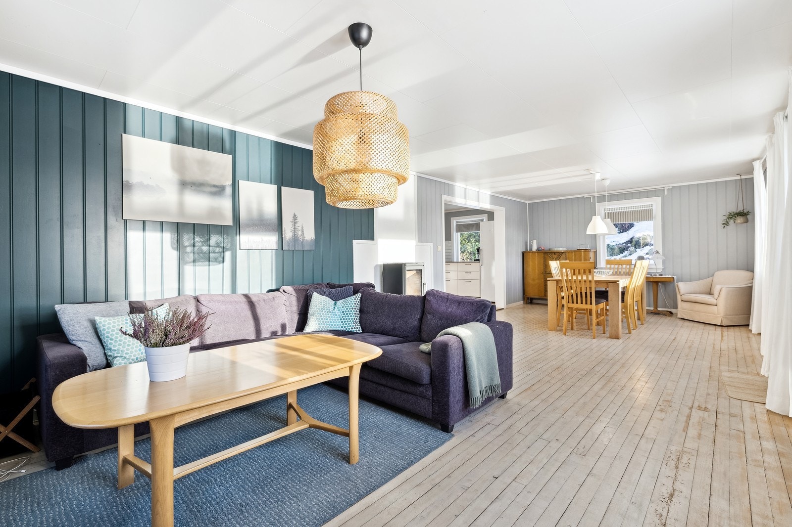 Lys og romslig stue med rikelig dagslys, peis og god plass til både sofa og spisebord. Galleribilde