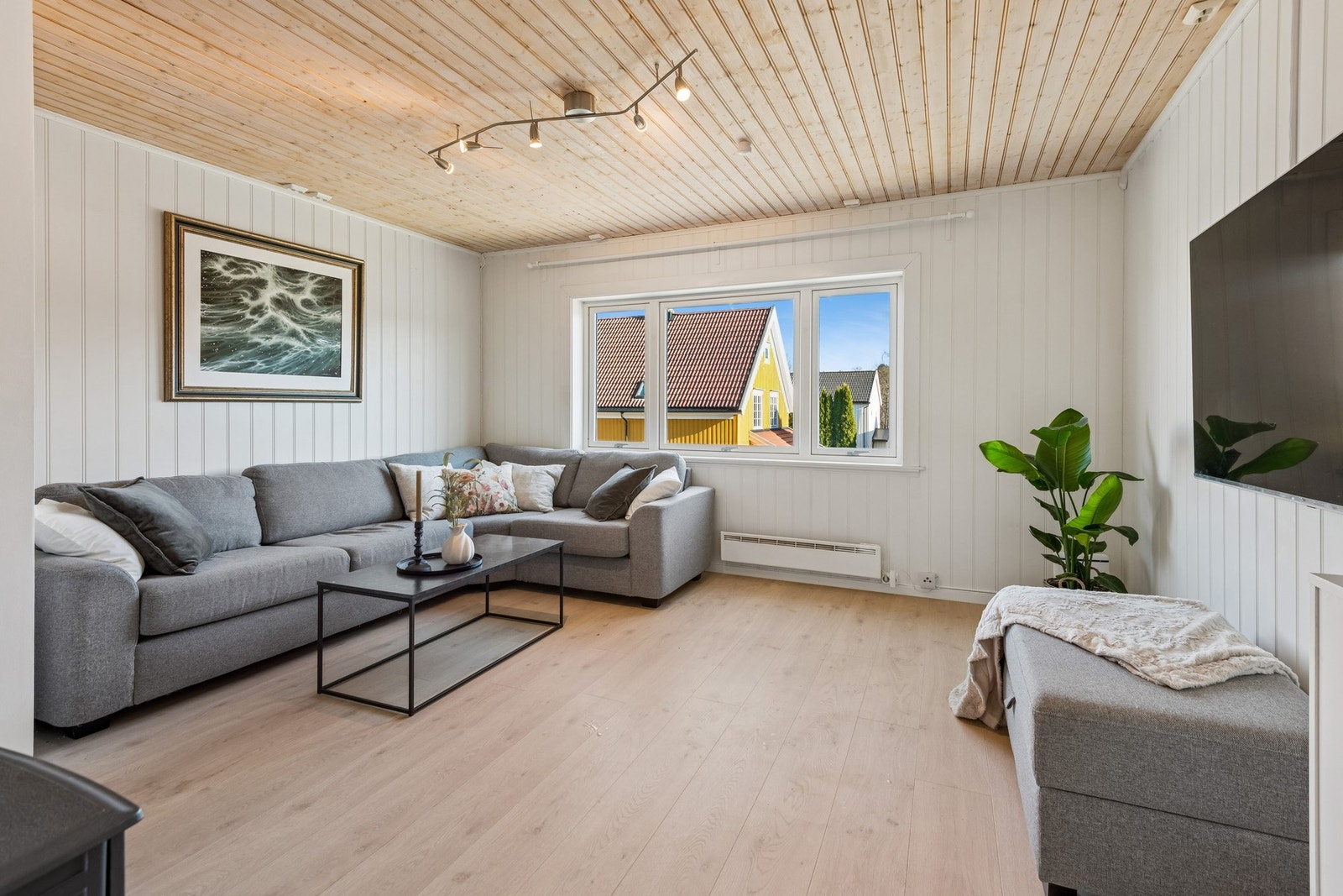 Store vindusflater på stue som slipper inn godt med naturlig lys. Galleribilde