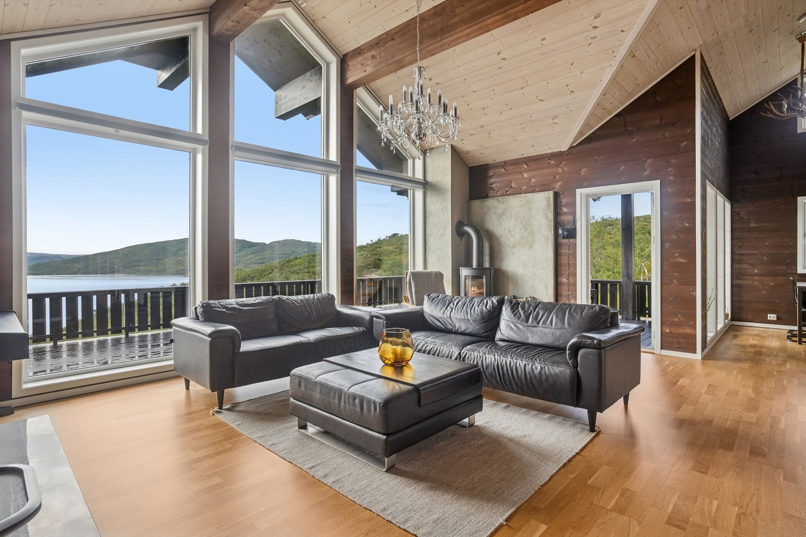 Stuen er romslig og lekker utført med parkett på gulv og vegger av trepanel - for en tradisjonell hyttefølelse i en moderne stil. Galleribilde