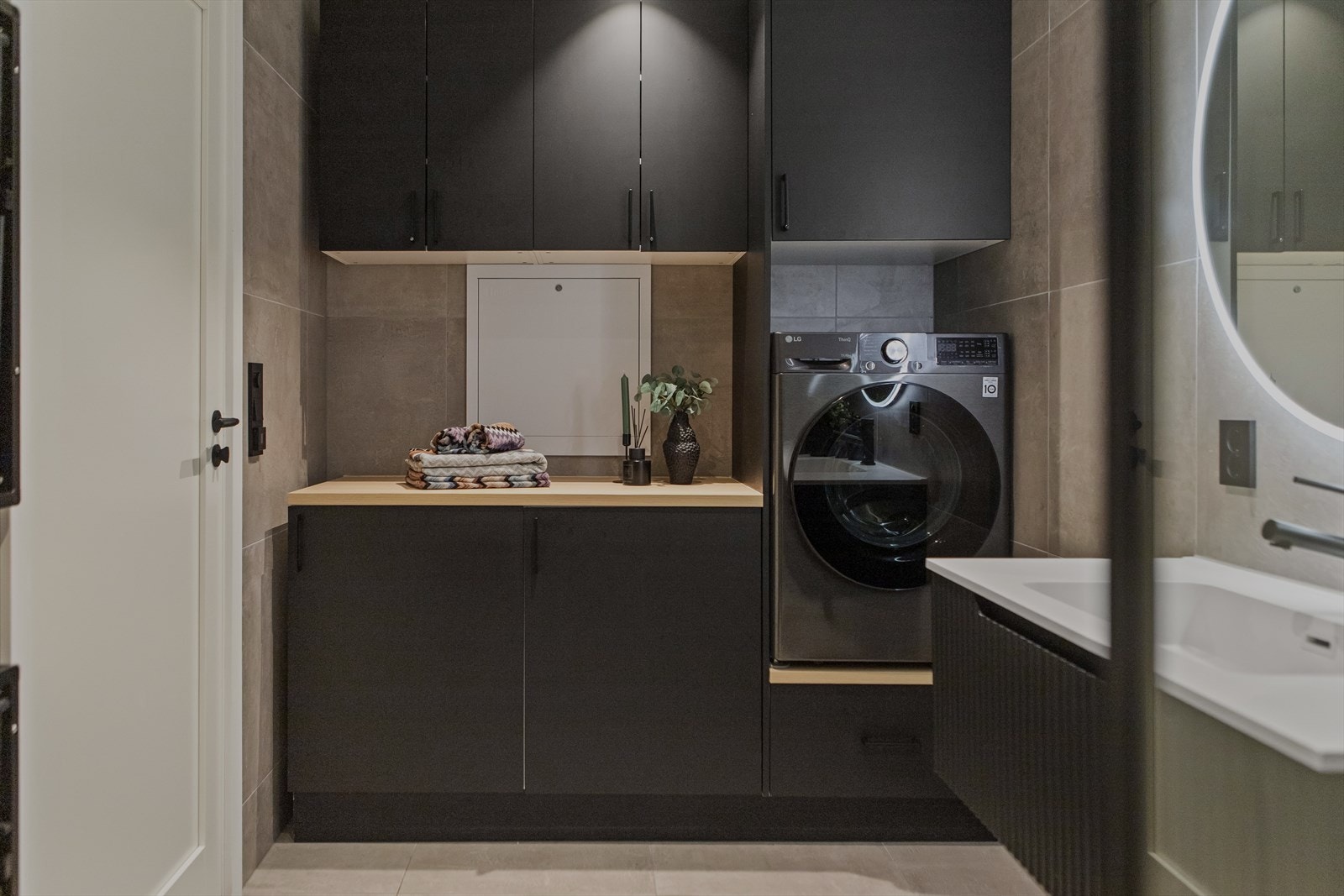 Dette badet fungerer også som et praktisk vaskerom med opplegg for vaskemaskin. Galleribilde