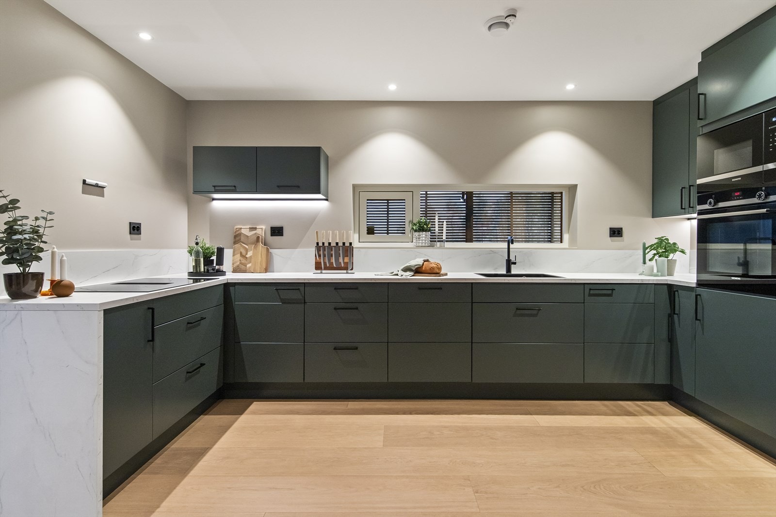 Kjøkkenet er innredet med glatte fronter og en praktisk benkeplate i laminat. Galleribilde