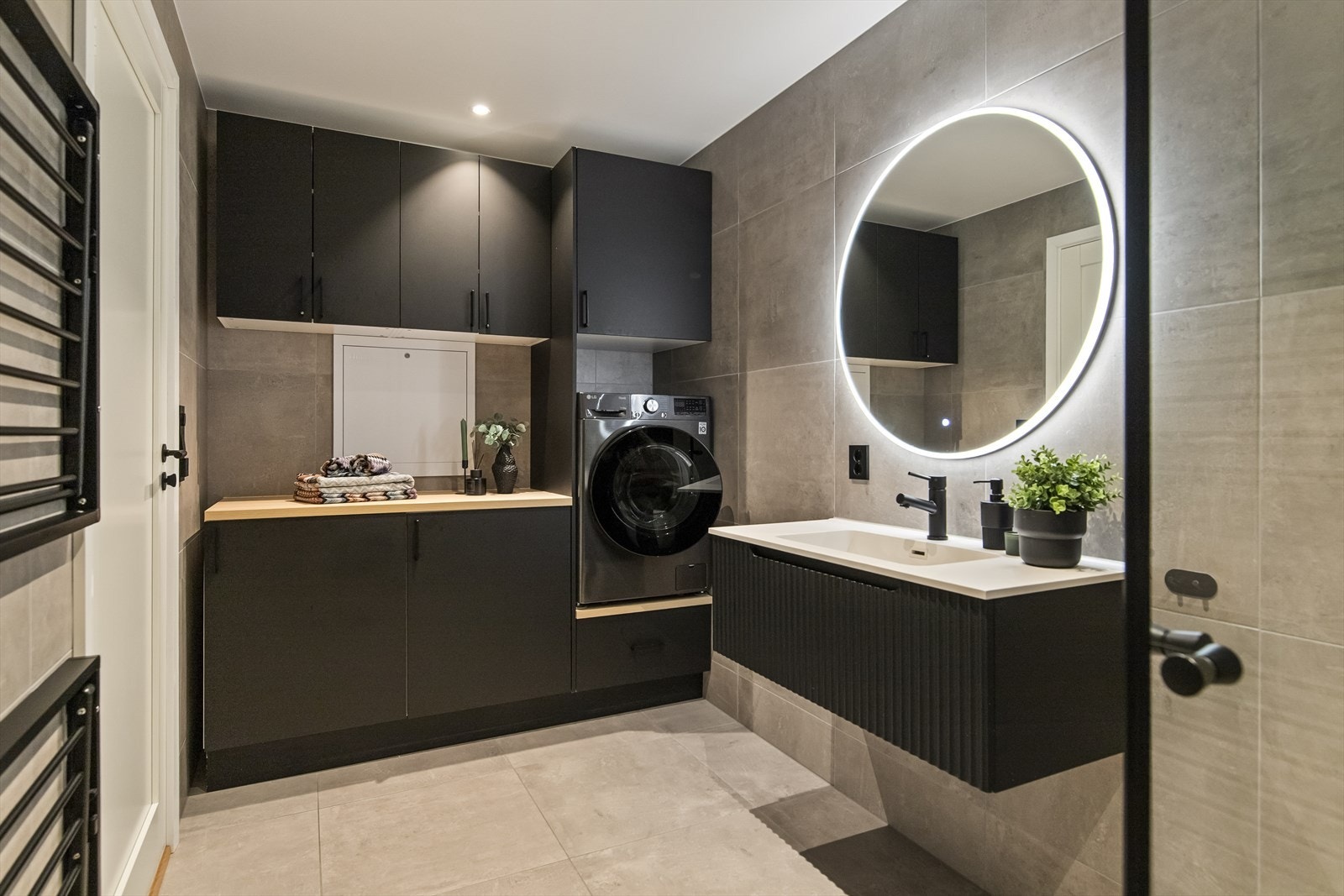 Badet er flislagt på både gulv og vegger, har varmekabler i gulv og er utstyrt med servant, vegghengt toalett og dusj. Galleribilde