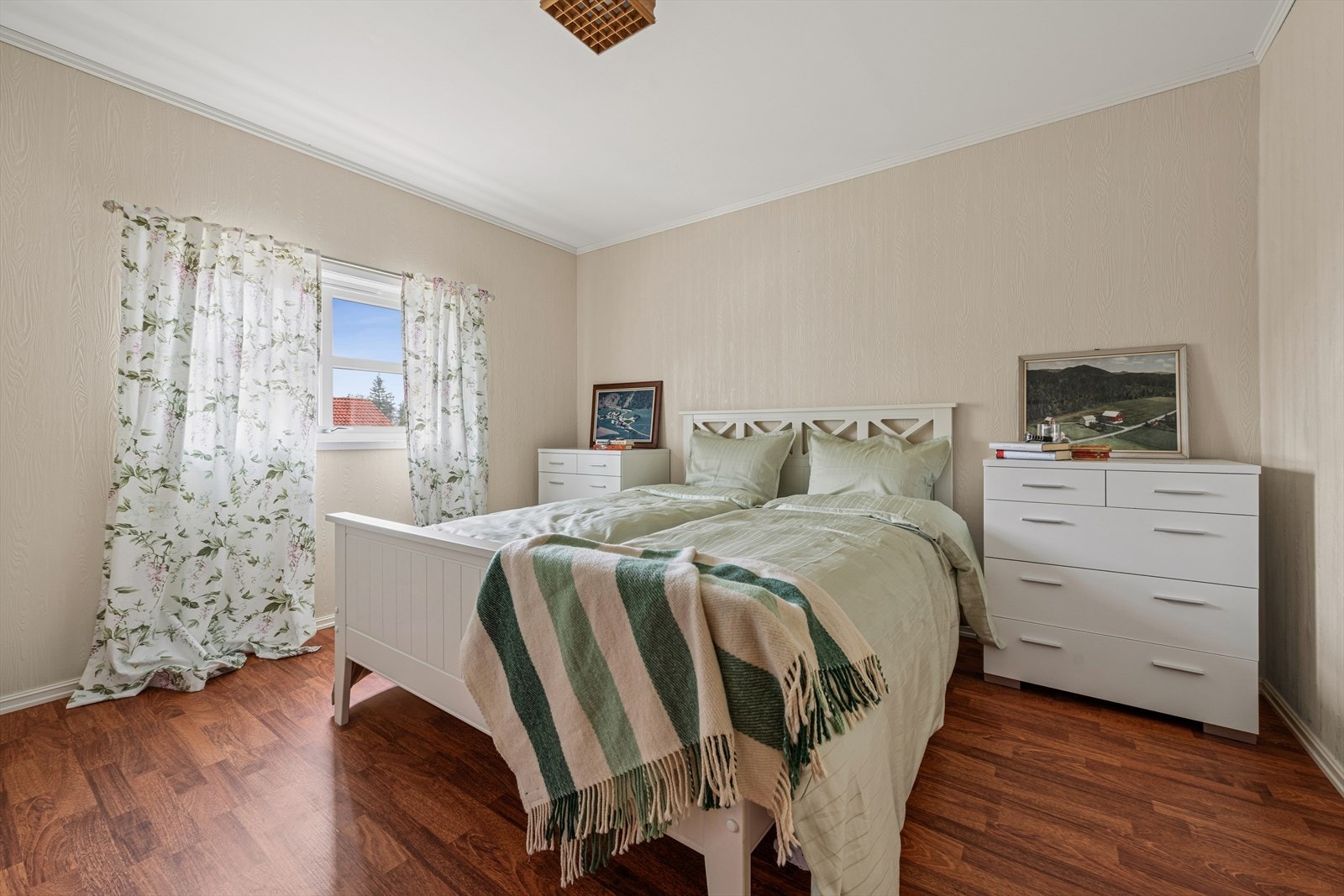 Et romslig og lyst soverom med laminat på gulvet. Galleribilde