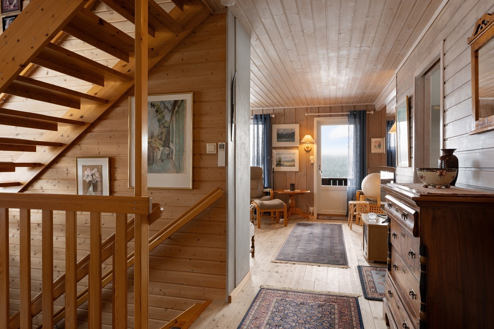 Gangen i 1. etasje har en solid tretrapp som fører opp til loftsetasjen og ned til kjelleretasjen. Galleribilde