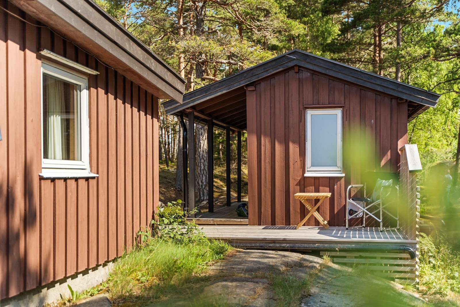 Annekset har en egen, overbygget terrasse og inneholder også en praktisk bod. Galleribilde